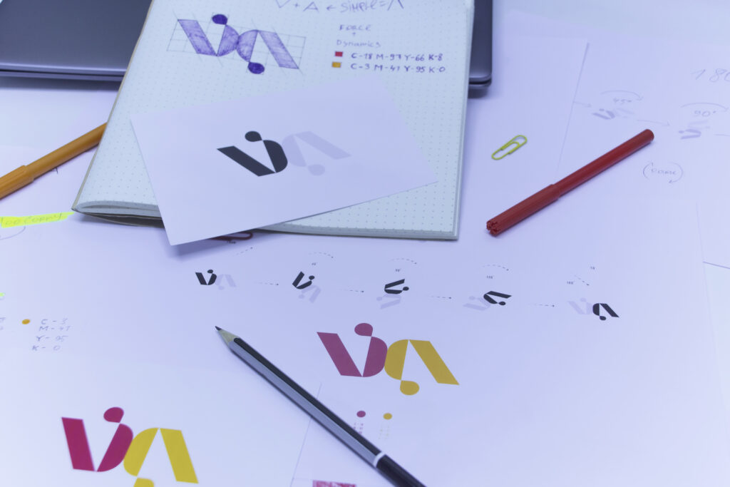 bocetos y dibujos del logo impresos en papel desarrollo de diseno de logo en estudio sobre mesa con laptop