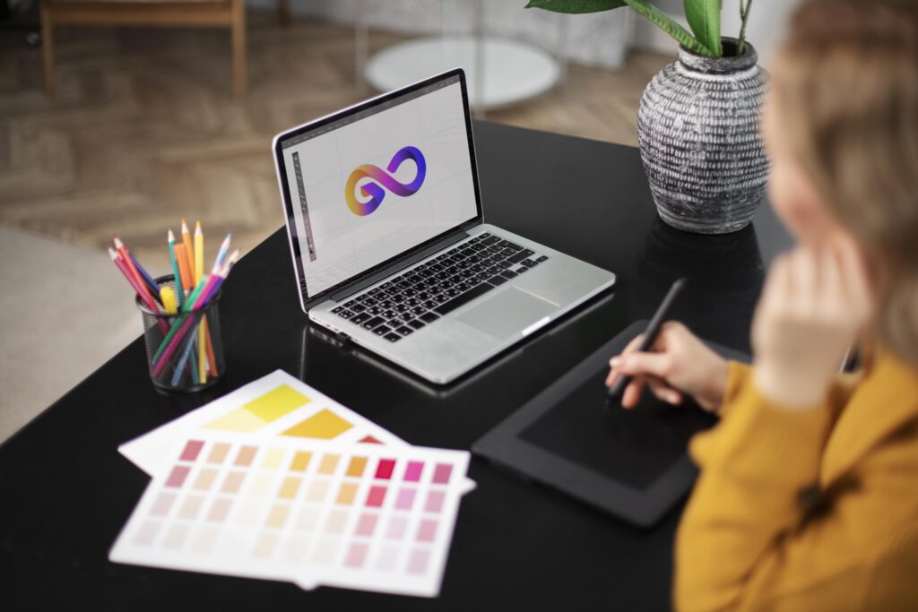 disenador de logotipo femenino trabajando en su tableta conectada una computadora portatil